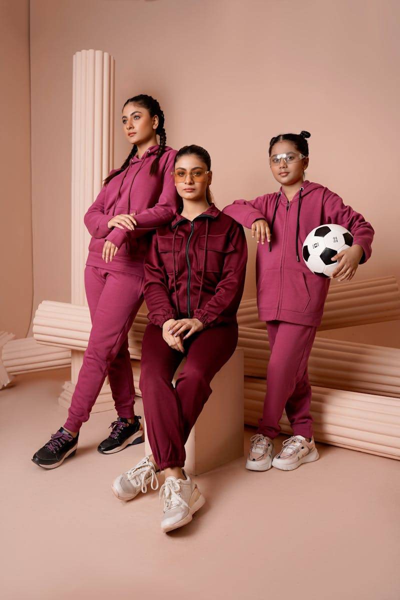 Family in stylish tracksuits posing indoors with modern decor.